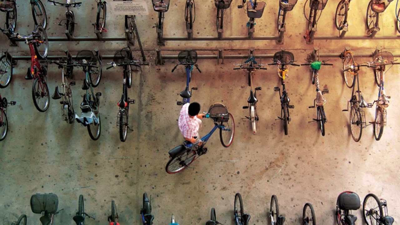 Top view of guy removing his bicycle from among others in a bicycle hangar.