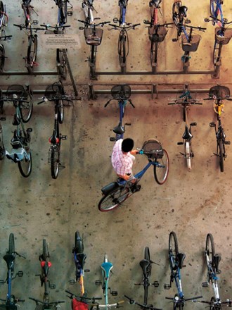 Top view of guy removing his bicycle from among others in a bicycle hangar.