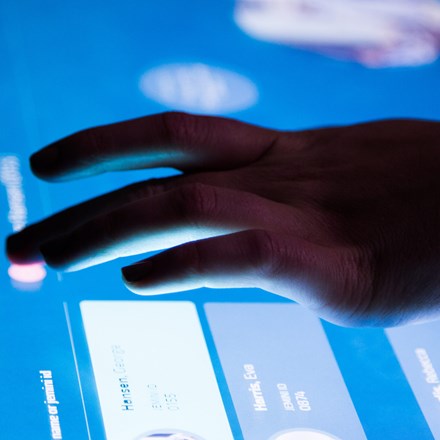 Hand touching a digital screen.