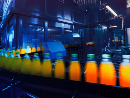 Bottles of orange juice in the manufacturing process.
