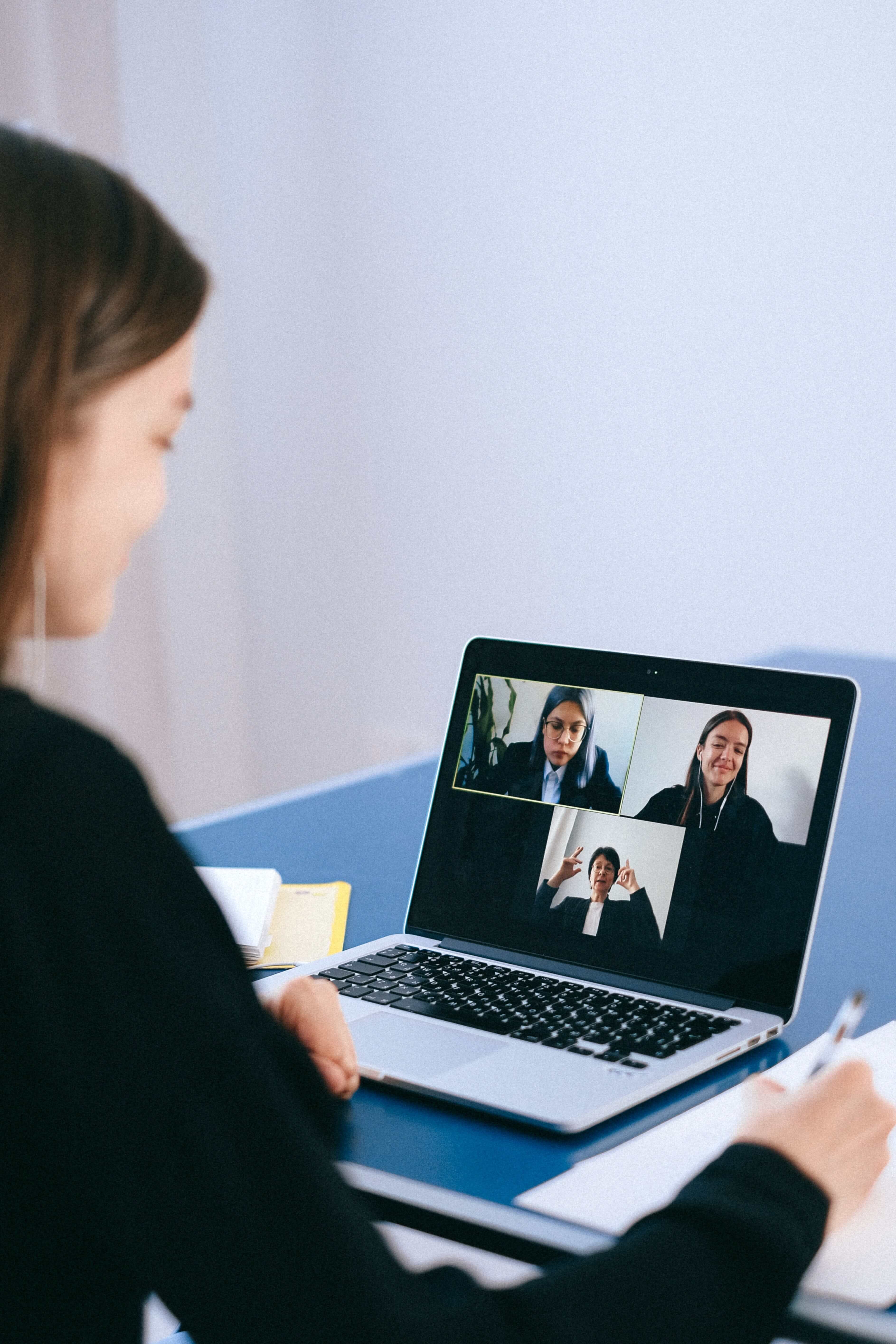 Someone in front of a laptop having a virtual meeting with other people