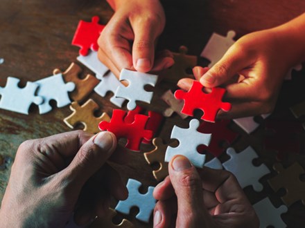 Business people Holding Jigsaw Puzzle, group of business people using a jigsaw puzzle to demonstrate the need to work in the same direction to work fully and effectively