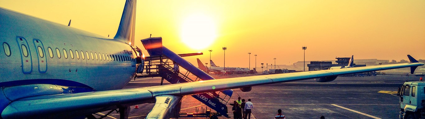 Passengers boarding an airplane at dusk.