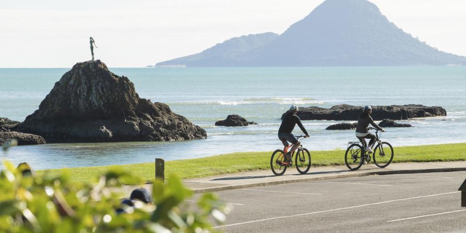Two people cycling along the Whakatane river. 