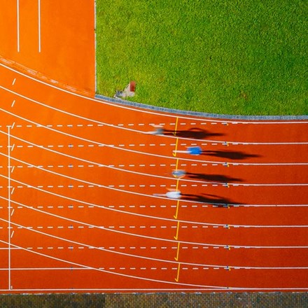 Top shot of athletes running on a track. 